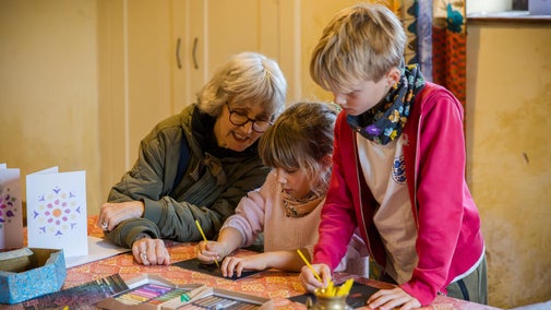 People sitting at a table doing craft activities